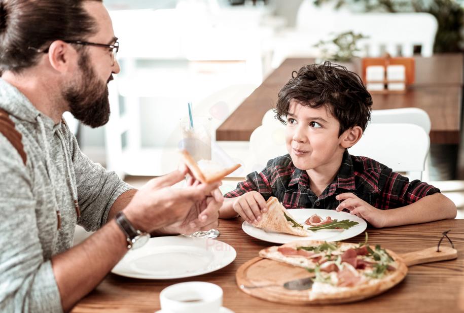 father and son eating in pizza restaurant