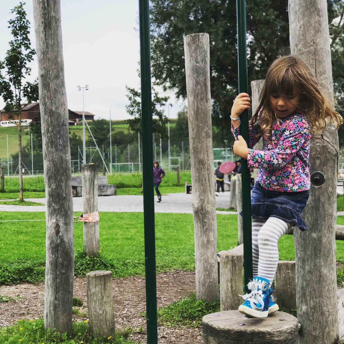 Girl at Erlenmoos Playground climbing and balancing