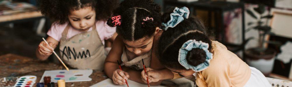 A group of pre-school and primary school girls absorbed in their art work all close to each other at a table in a workshop at the Benaki Museum in Athens, Greece.