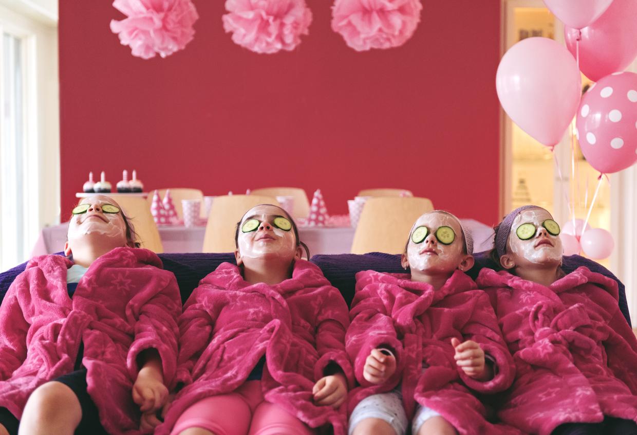 A group of girls in matching robes at a spa celebrating their birthday with a face mask and cucumber eyes