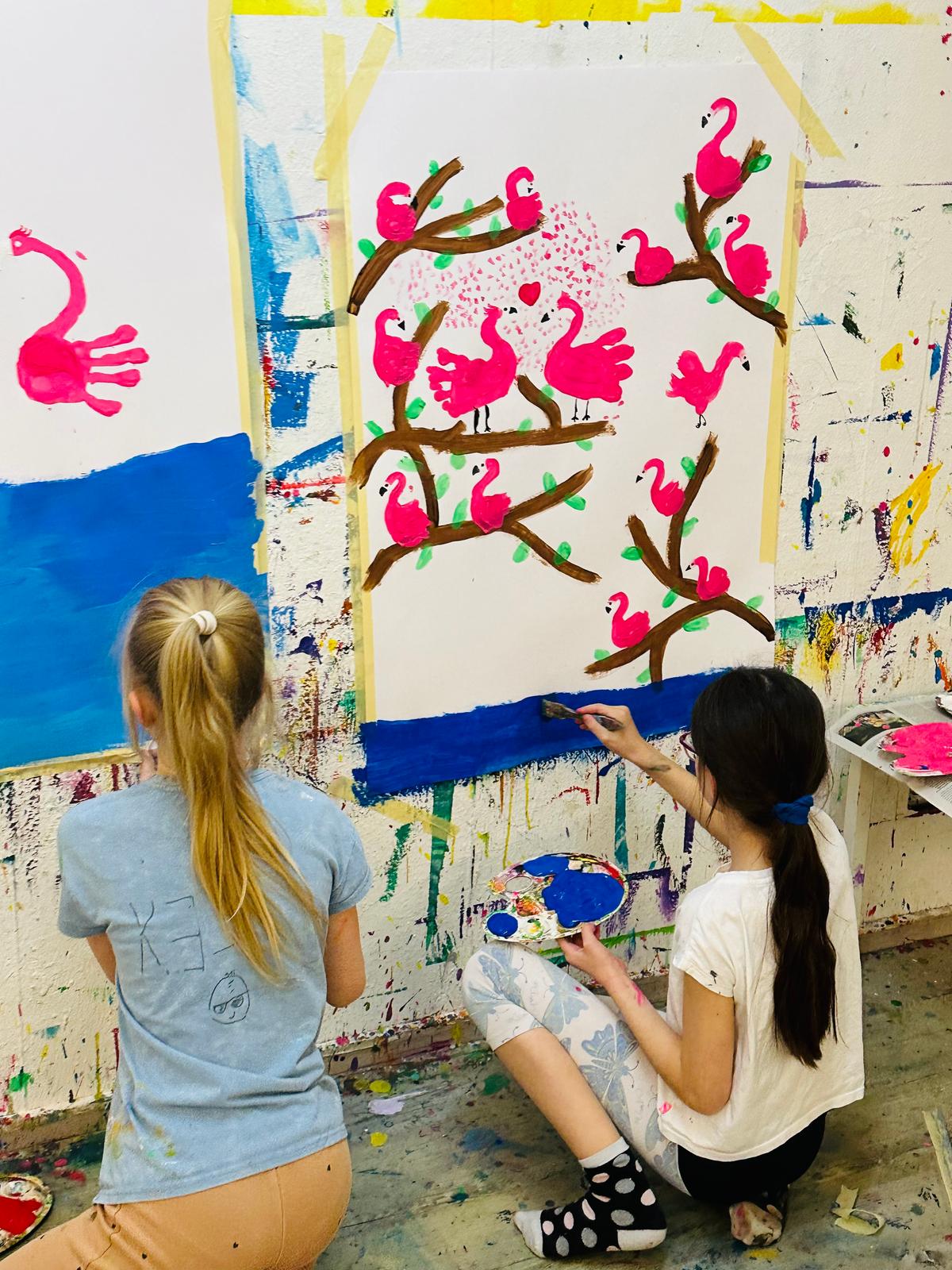 tween girls painting art on wall