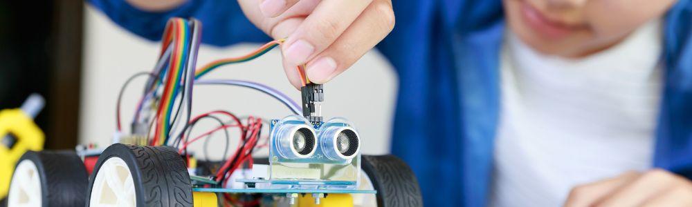 A young teen powering a robot that he built with team-members at MIT Kids, a coding and robotics workshop provicer in Kifisia, Athens, Greece.