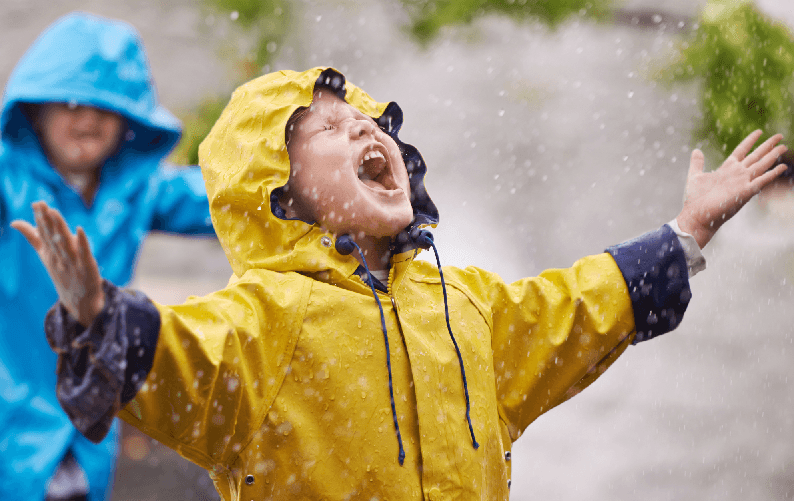 child in rain jacket shouting fun