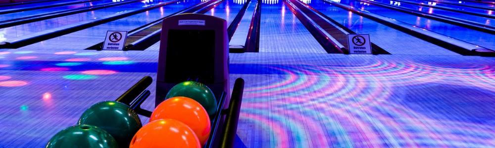 An image of a bowling alley lit with blue and fluorescent light at blue cinema bowling where teens and pre-teens love to go in Luzern, Switzerland