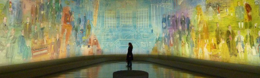 A teenage girl is at the center of an audio-visual art exhibition at the museum where she is immersed in light and color.  She is experiencing works of art up close and personal at the museum. 