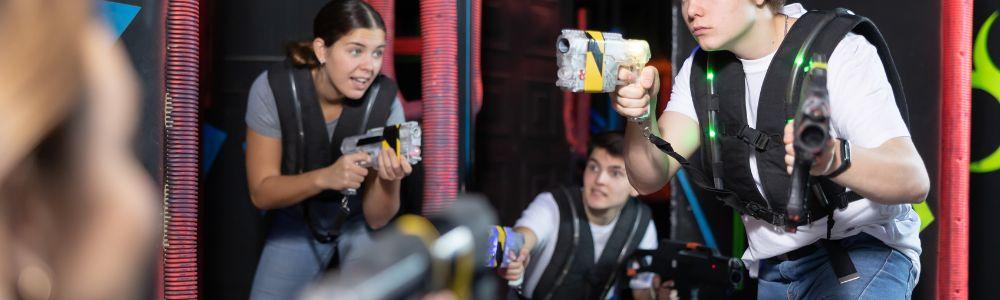 A group of teenagers with 2 boys and a girl are battling each other with lazers at Laser Arena Zurich, in Switzerland.