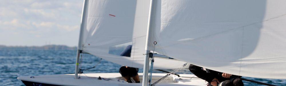 Two laser sail boats photographed sailing next to each other in a close-up to the mast at the sailing club in Voula, Athens, Greece