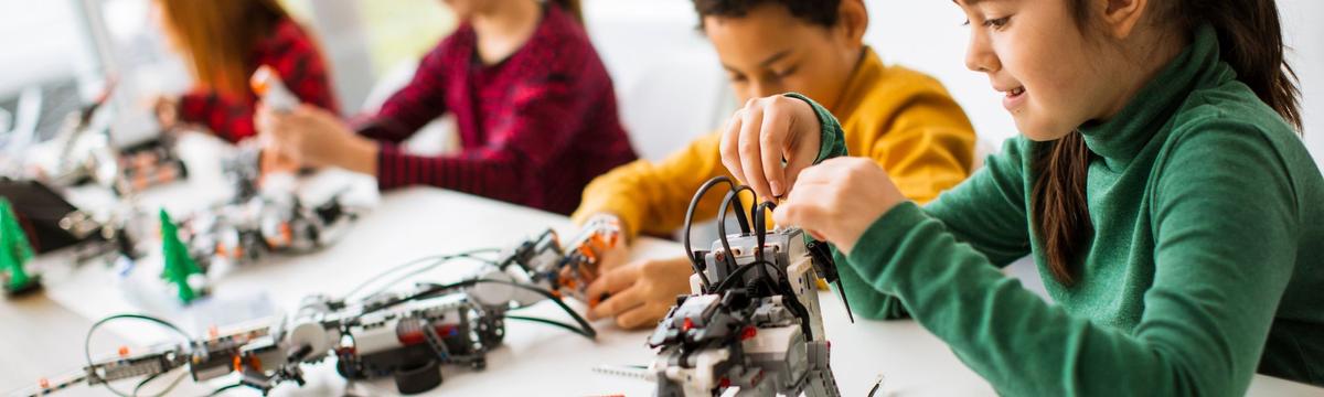 Children building creative structures with colorful bricks and construction toys at Buildastic, fully engaged in imaginative, hands-on play in a vibrant indoor space