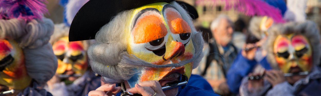 A masked caricature parading at the Fastnacht parade in Basel, Switzerland, the most popular carnival parade in the country open to families, kids and all ages.  