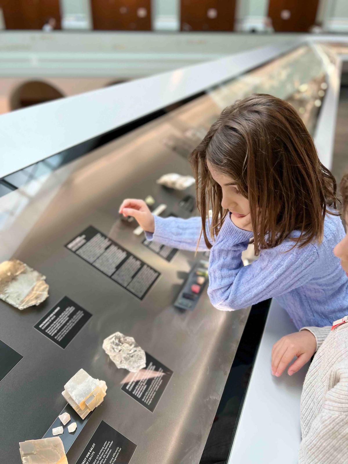 A young girl at Focus Terra Museum in Zurich is observing the different types of crystals on display.