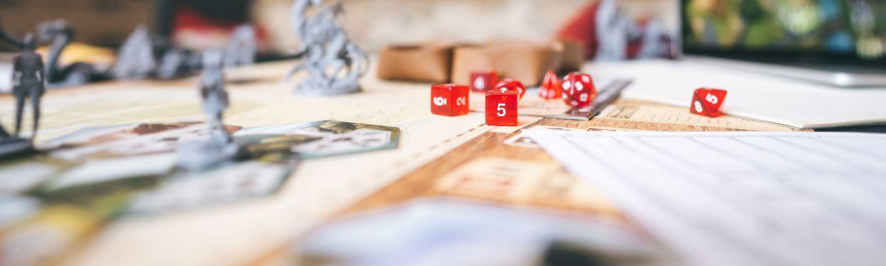 A close-up of 4 red dice on a Risiko board game for families, where players must conquer regions and armies to win the game.  