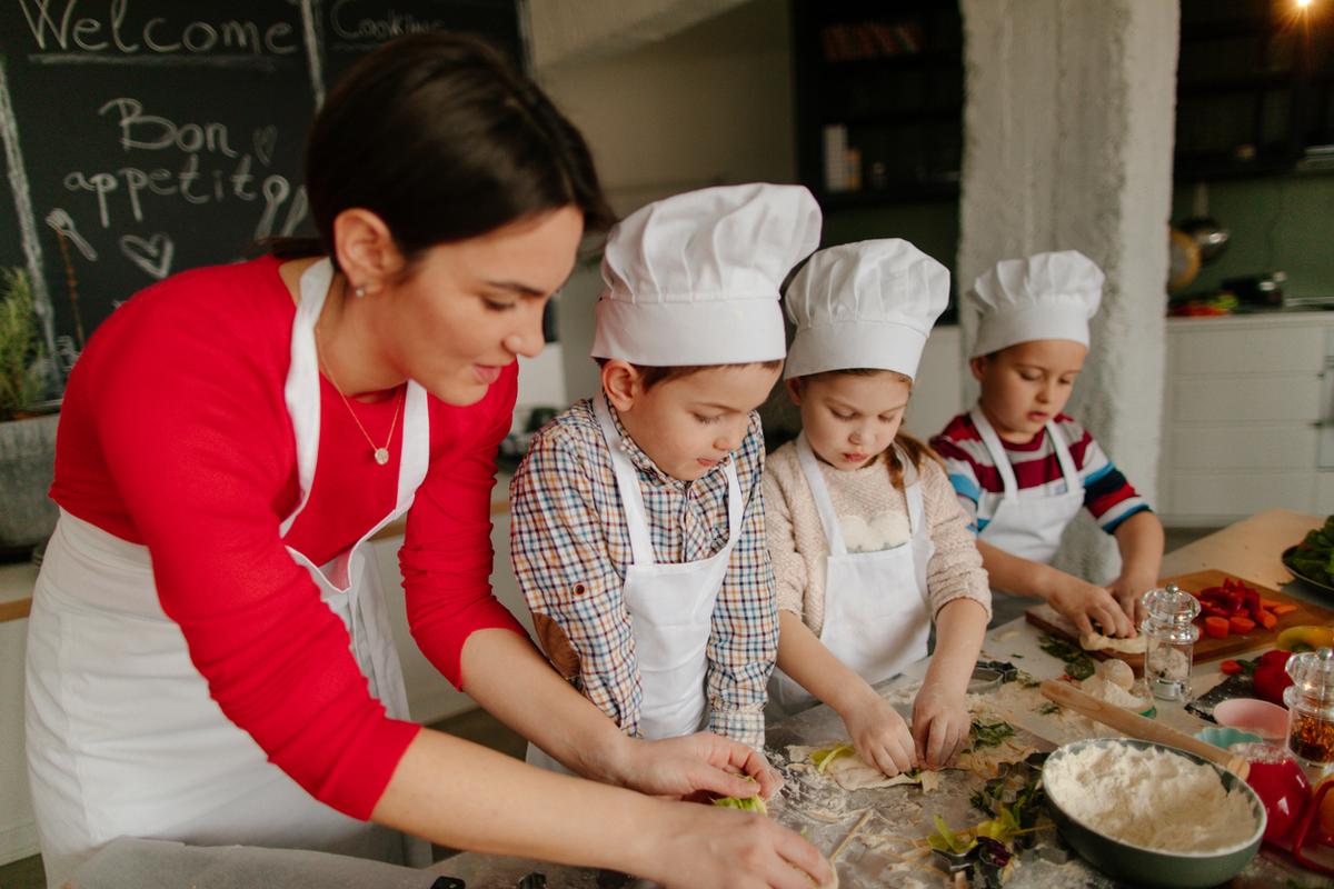 Young children in a cooking course with the teacher at vegetarian restaurant Hiltl in Zurich