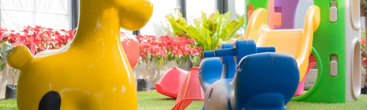 Bright and colorful indoor play area at Toys Land, filled with slides, ball pits, soft play structures, and children joyfully running and playing.