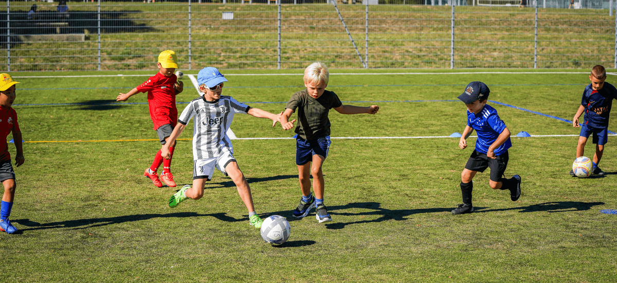 Children playing football on a summer's day at Intersoccer after-school classes in Zug, Switzerland. 