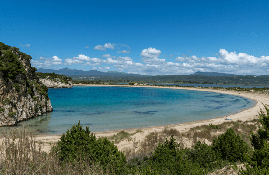 Πανοραμική θέα της παραλίας Βοϊδοκοιλιά με γαλαζοπράσινα νερά, αμμώδη ακτογραμμή και φυσική βλάστηση.